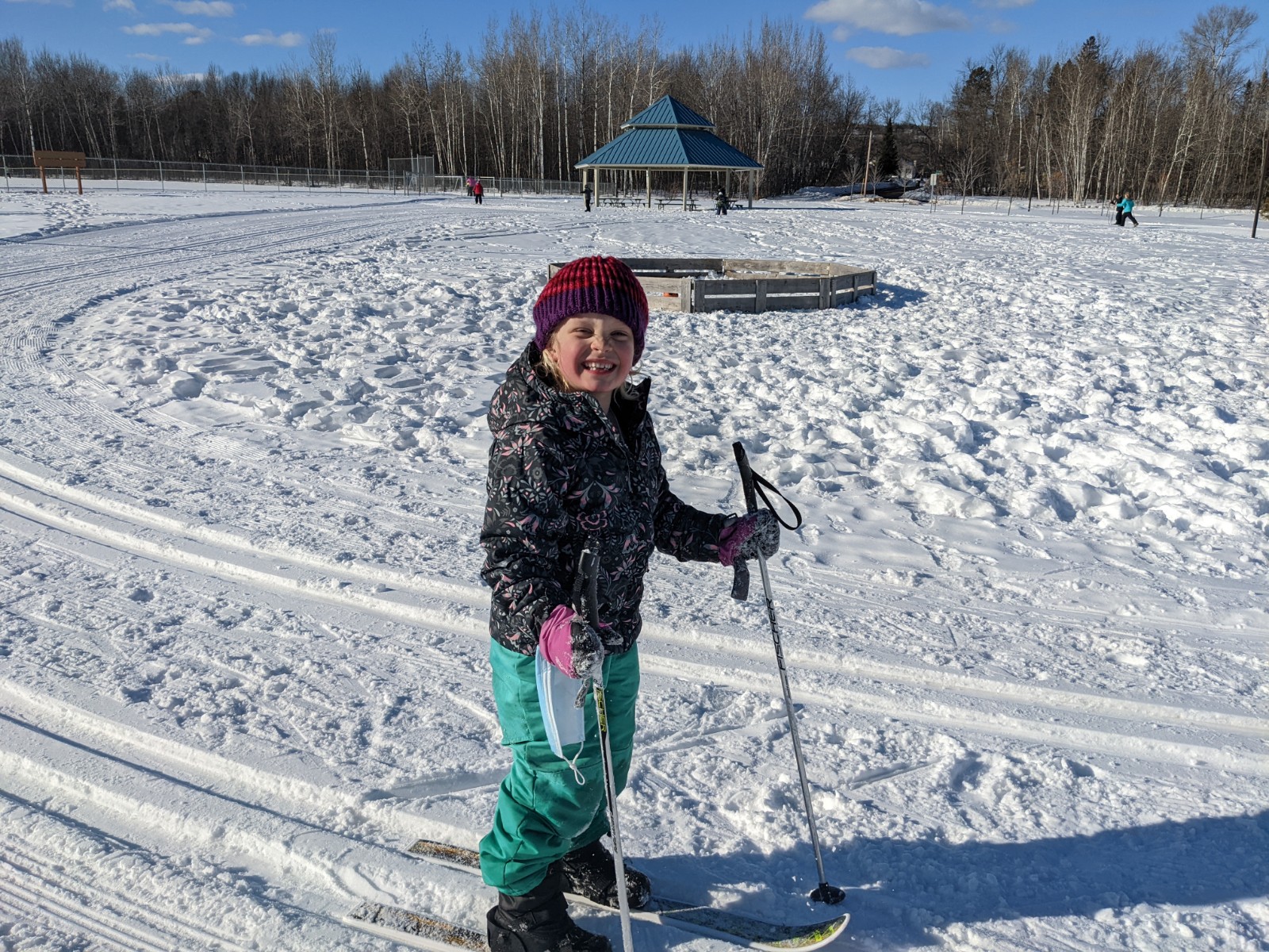 A young girl smiles while cross country skiing by the Pavilion at the GND REC