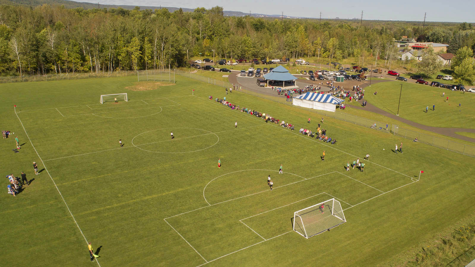 An aerial view of the soccer field at the GND REC, with children playing and people watching
